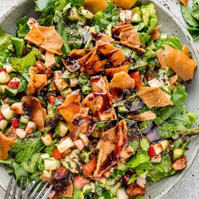 Fattoush salad with crisp pieces of fried bread, chopped greens, cucumber and tomato, drizzled with pomegranate dressing