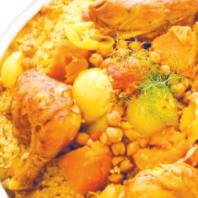 Bucăți de pui pe cuscus palestinian, cu năut, cartofi și morcovi, într-un bol alb