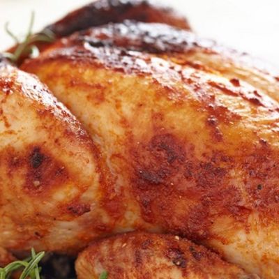 A whole chicken stuffed with rice and minced meat, roasted in the oven